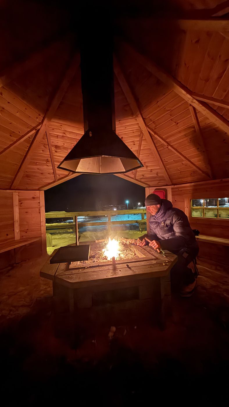 A fire burning inside a wooden hut