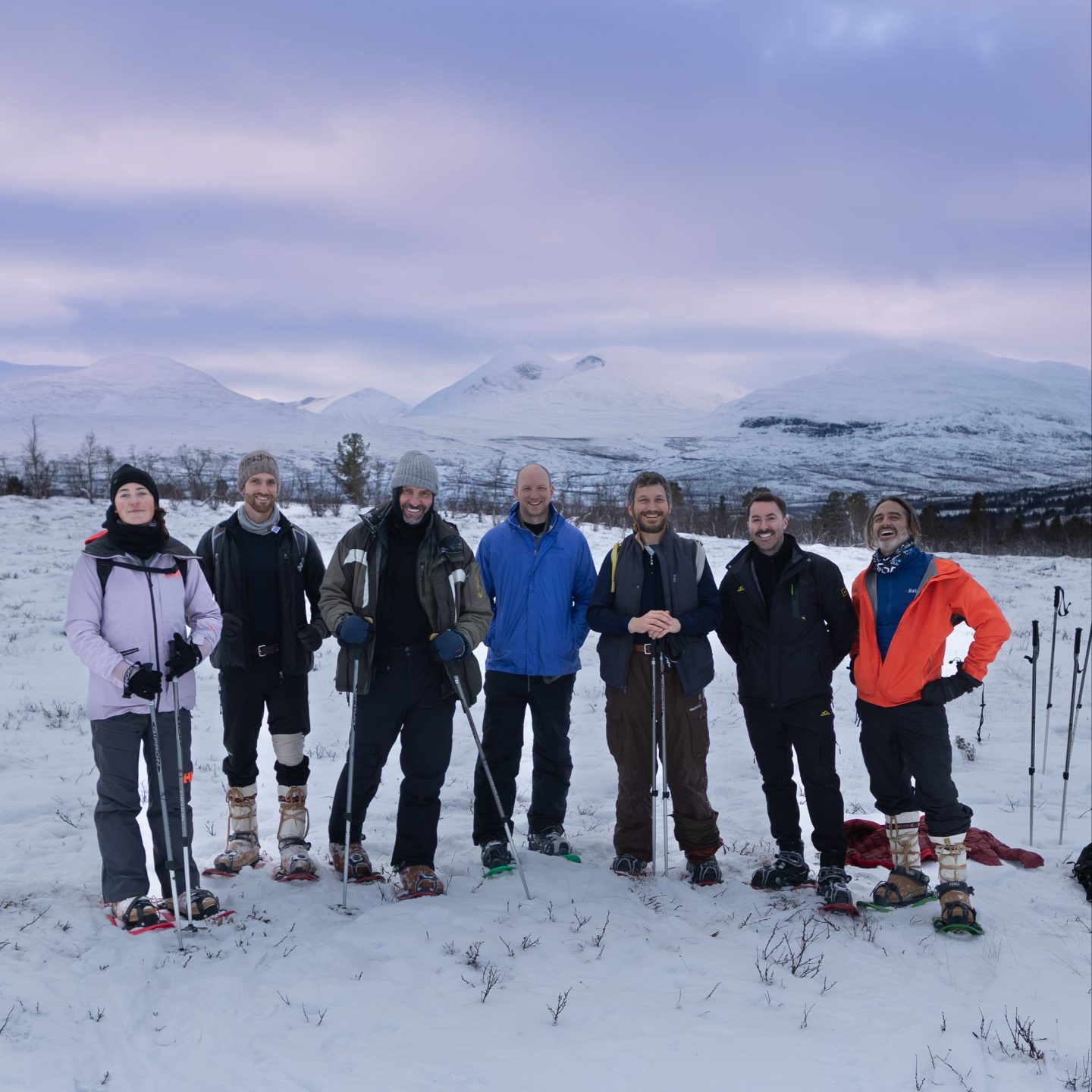The group on snowshoes in front of snowy mountains