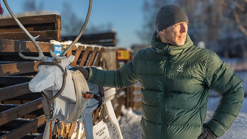 Jonas Stenström standing beside a reindeer sled in the snow