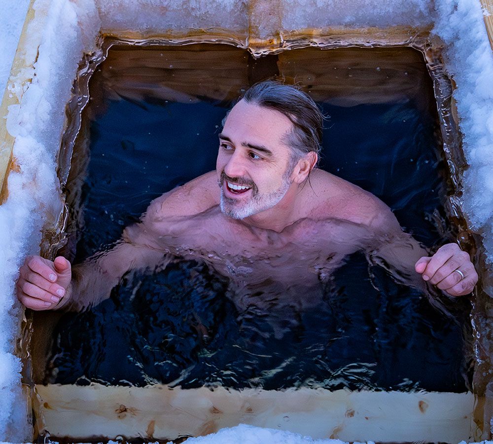 Rob Nelson grinning from a hole in the lake ice