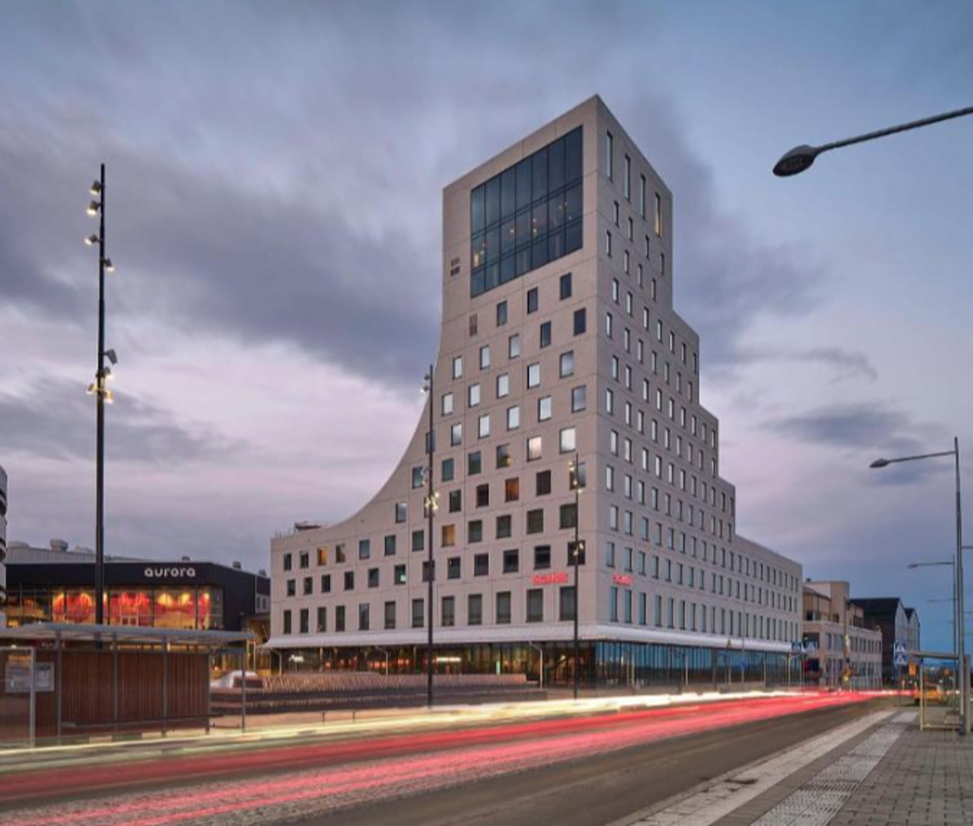 Scandic Kiruna, a tall pale hotel in the new town centre at dusk